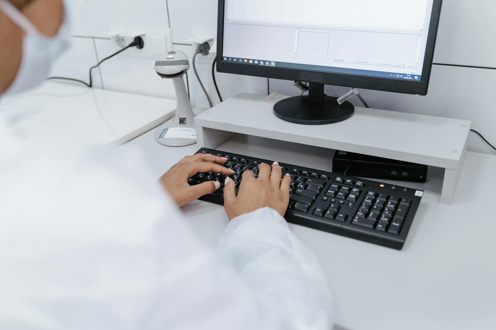 Ilustrasi: Scientist in white coat using a computer in a laboratory setting, focusing on data analysis.