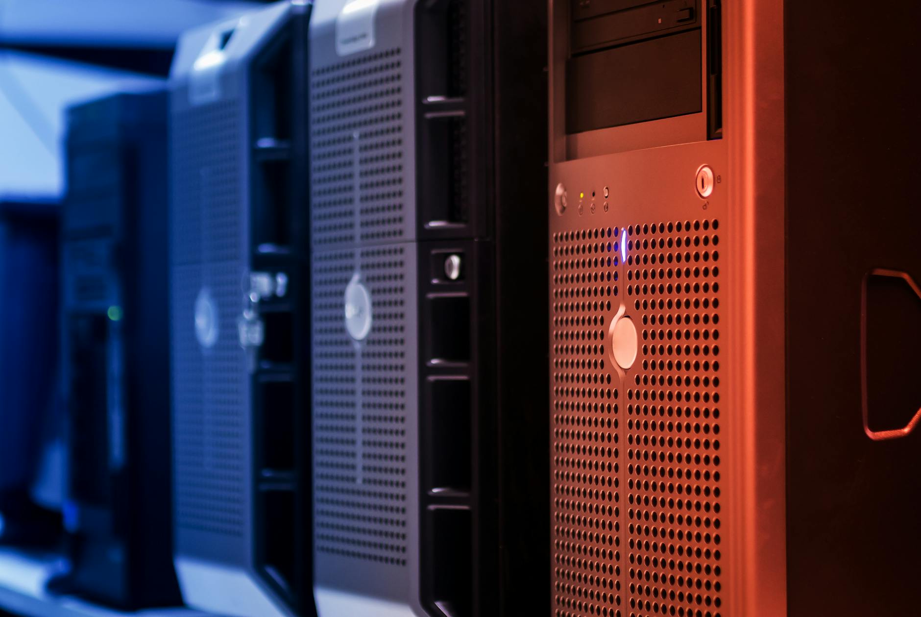 Ilustrasi: Close-up of tower servers in a data center with blue and red lighting.