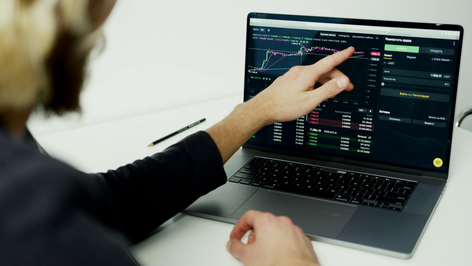 Ilustrasi: A person analyzing stock market graphs on a laptop screen, showcasing trading insights.